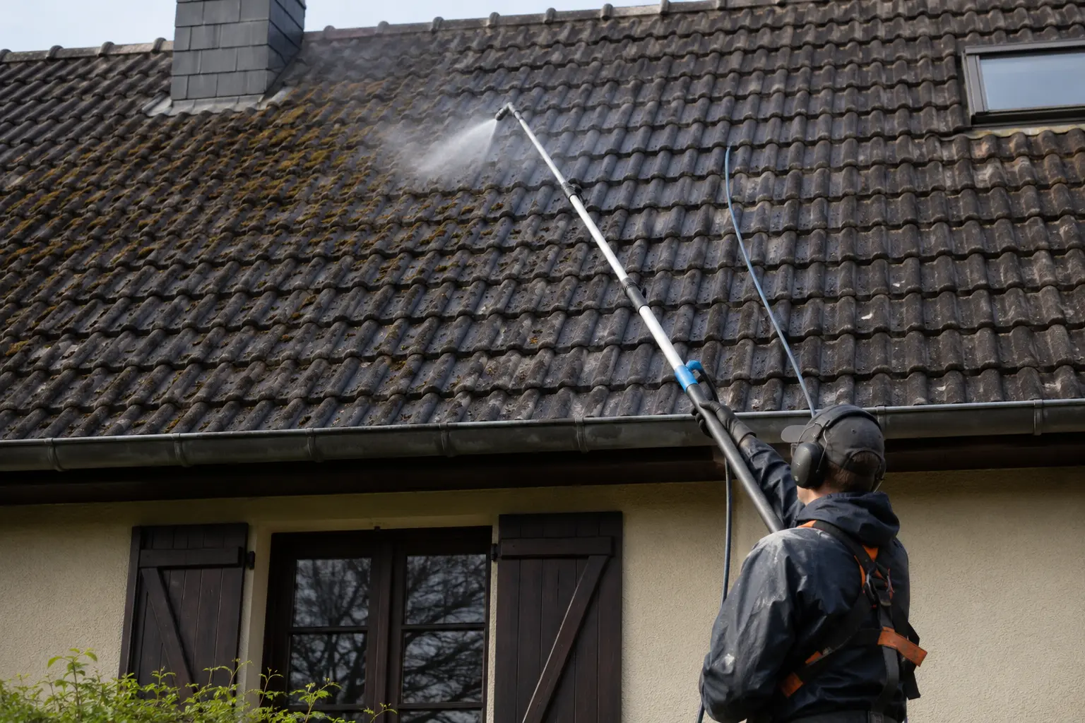 Pulvérisation d’un produit antimousse sur une surface de tuiles, buse basse pression, abords protégés